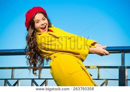 Kid Little Girl Yellow Coat Red Beret Enjoy Fall Stand Railing Riverside Blue Sky Background. Bright