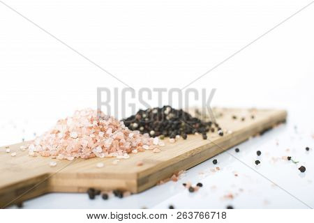 Himalayan Rock Salt And Peppercorns, Set Against A White Background.