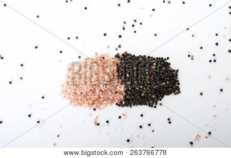 Himalayan Rock Salt And Peppercorns, Set Against A White Background.
