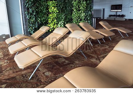 Chair For Passenger With Sunlight From Window In Morning Day At Airport. Soft Comfortable Sunbeds In