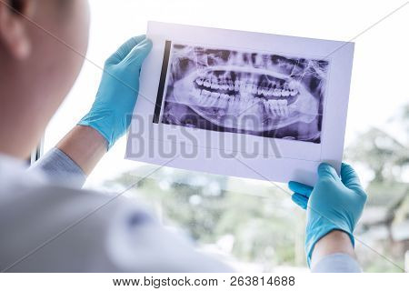 Image Of Male Doctor Or Dentist Holding And Looking At Dental X-ray.