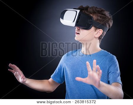 Happy Teen Boy Wearing Virtual Reality Goggles Watching Movies Or Playing Video Games. Cheerful Smil