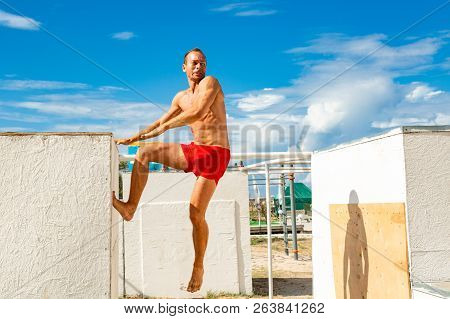 Young Man Practicing Yoga In A Urban Background. Parkour