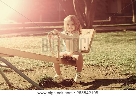 Girl Smile On Seesaw On Sunny Day. Child Have Fun On Playground. Balance, Equilibrium, Harmony. Kid 
