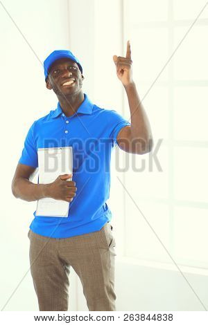 Portrait Of An Handsome Happy Deliverer With Folder
