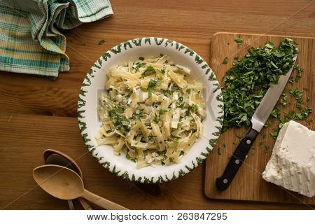Turkish Noodle / Eriste With Cheese And Parsley On A Wooden Surface.