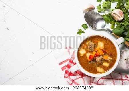 Traditional Hungarian Goulash Soup On White Stone Table. European Cuisine. Top View With Copy Space.