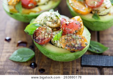Avocado Stuffed With Pesto Caprese Salad With Cherry Tomatoes And Mozarella