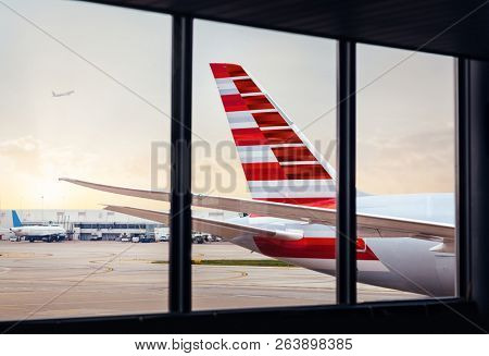 View of airplane fuselage tail through window at airport