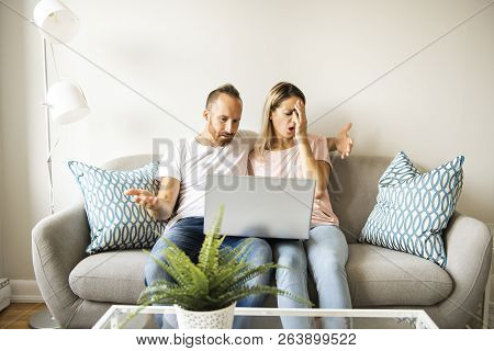 Portrait Of A Young Man With His Girlfriend On Laptop At Home Indoor