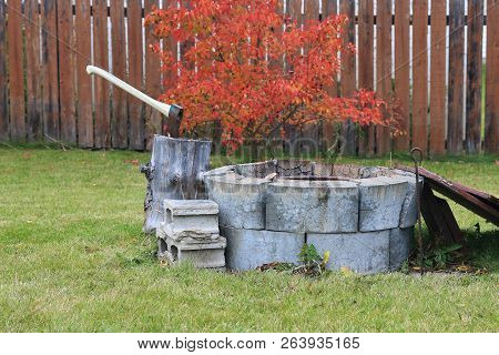 Autumn Scene Of A Fire Pit With Red Autumn Trees In The Background