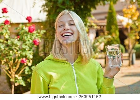Young Woman Drinking Water. Beauty Girl Drinking Water From Glass On Flover Background. Face Portrai