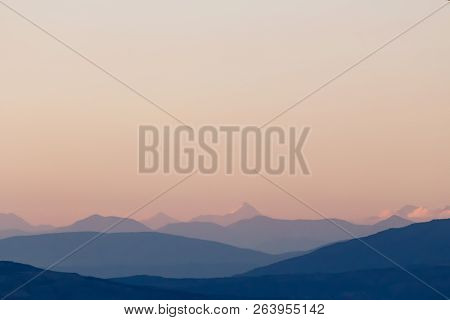 Purple Mountain Silhouettes And Clear Sky. Gradient From Dark To Light Purple. Caucasus Mountains.