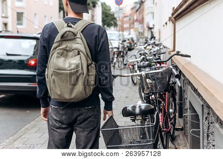 Tourist With A Backpack Is Looking For Booked Online Accommodation In An Unfamiliar City