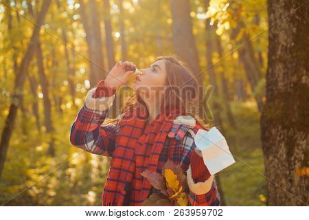 Young Woman With Nose Wiper Near Autumn Tree. Portrait Of Young Woman Sniffing Nasal Spray Closing O