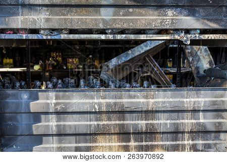 Close Up Damaged Industry Supermarket Metallic Facade After Arson Fire With Burn Debris Of Beer Bott