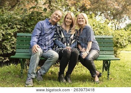 A Family Sit On Bench A Autumn Season