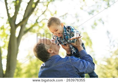 Grandfather And Littleson Having Fun In The Park