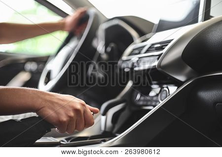 The Man Sits Behind The Wheel Of A Passenger Car And Pulls The Handbrake.