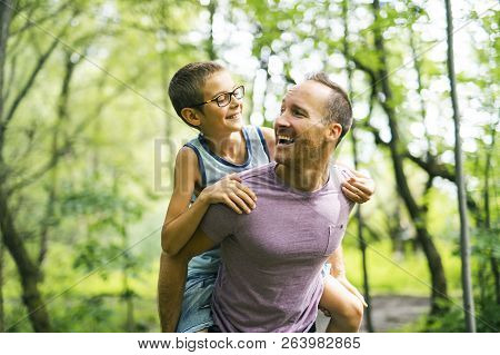 Father Giving His Son A Piggyback Ride, Having Fun