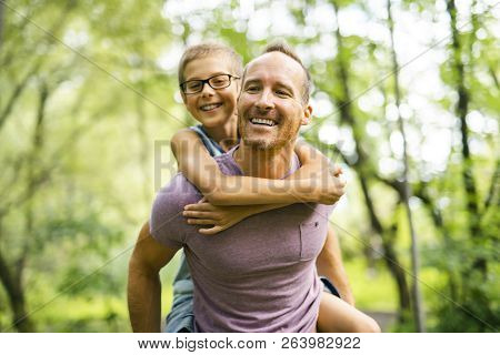 Father Giving His Son A Piggyback Ride, Having Fun