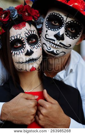 A Couple, Wearing Skull Make-up For. All Souls Day. Boy And Girl Sugar Skull Makeup.painted For Hall