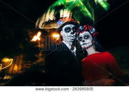Blur. A Man And A Woman With A Visage, A Pattern Of Skulls, A Zombie On The Face. Dead At Night. A P
