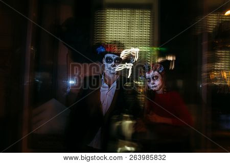 Blur. A Man And A Woman With A Visage, A Pattern Of Skulls, A Zombie On The Face. Dead At Night. A P