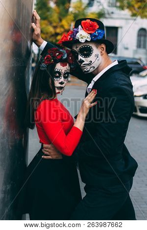 A Couple, Wearing Skull Make-up For. All Souls Day. Boy And Girl Sugar Skull Makeup.painted For Hall