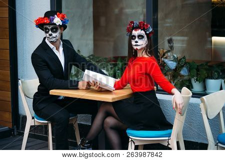 A Couple, Wearing Skull Make-up For. All Souls Day. Boy And Girl Sugar Skull Makeup.painted For Hall
