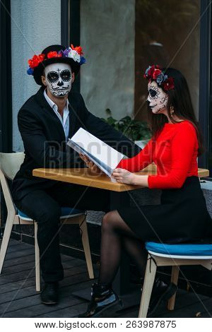 A Couple, Wearing Skull Make-up For. All Souls Day. Boy And Girl Sugar Skull Makeup.painted For Hall