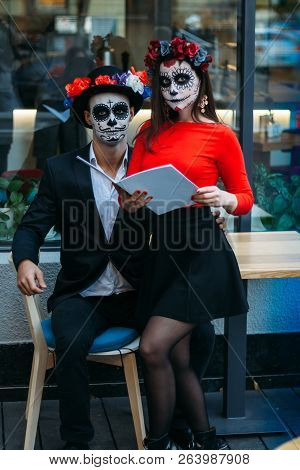 A Couple, Wearing Skull Make-up For. All Souls Day. Boy And Girl Sugar Skull Makeup.painted For Hall