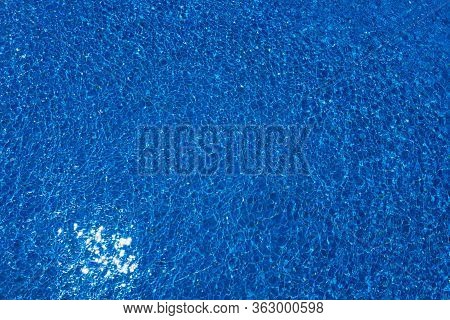 Swimming Pool, Blue Clear Water In The Outdoor Pool, With Sun Flare On The Surface. Background Of Bl