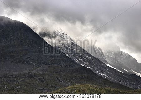Some Snowy Mountains Aligned Under The Clouds