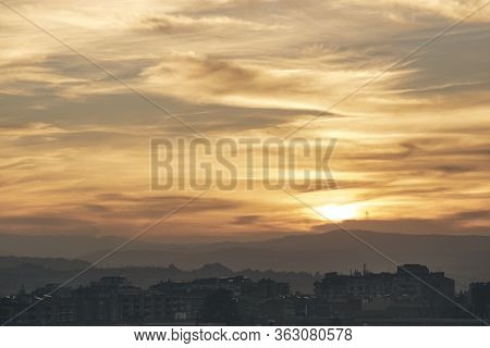 Beautiful Sunset View Of Igualada City Under A Cloudy Sky And Some Mountains In The Background