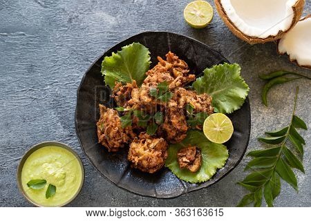 Indian Cuisine. Pakora Traditional Indian Deep-fried Snack. Pakoras On Black Plate With Coconut Chut