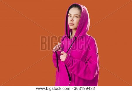 Beautiful Caucasian Sporty Woman To Trendy Red Hoodie On Colorbackground In Studio