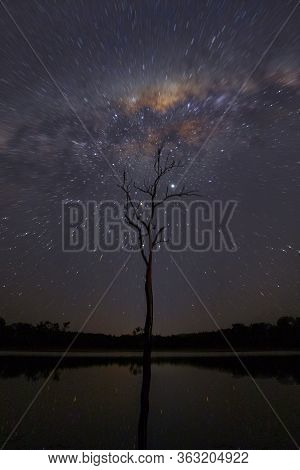 Milkyway Radial Blur And Sunset Glow In The Sky Over A Tre In Dam Water