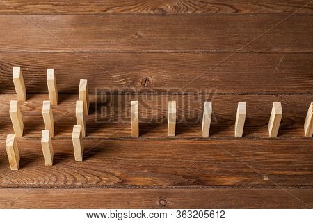 Rows Of Dominoes Standing On Wooden Table. Business Assistance And Management Concept With Wooden Bl