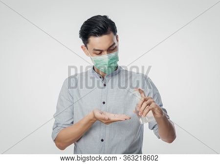 Young Asian Businessman Wearing Hygienic Mask And Using Hand Sinitizer Or Alcohol Gel, Prevent Infec