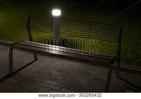 View Of A Bench On The Sidewalk In Siofok, Hungary During The Night