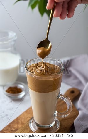 Spreading Foam On A Dalgon Coffee Spoon. Korean Drink In A Tall Glass With Whipped Coffee