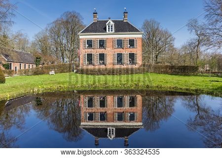 Midwolda, Netherlands - April 11, 2020: Historic Mansion Ennemaborg With Reflection In The Pond In M