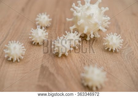 covid19, 3d printed representation of the virus on a wooden surface. home security and protection against viruses