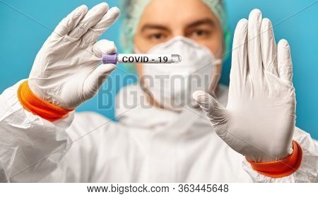 Express Test On Coronavirus. Scientist In Protective Coverall And Mask Hold Medical Tube With Test F
