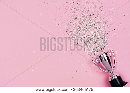 One Silver Winners Cup With Sparkles On A Pastel Background. Banner With Copy Space. Flat Lay Style.