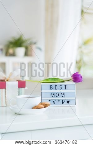 Mother's Day Background. Morning Suprise - Cup Of Tea With Cookies, Gift Box, Lightbox With Words Be