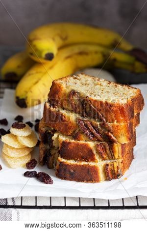 Banana Muffin With Candied Ginger And Raisins And Bananas On A Gray Background.