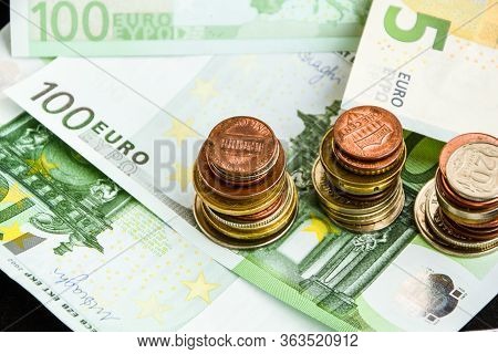 Euro Coins On Banknote Money Background, A Coin On The Background Of Stacks Of Coins And Banknotes