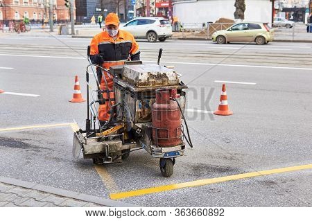 Perm, Russia - April 27, 2020: Worker Update Markup At The Bus Stop Using A Road Marking Machine